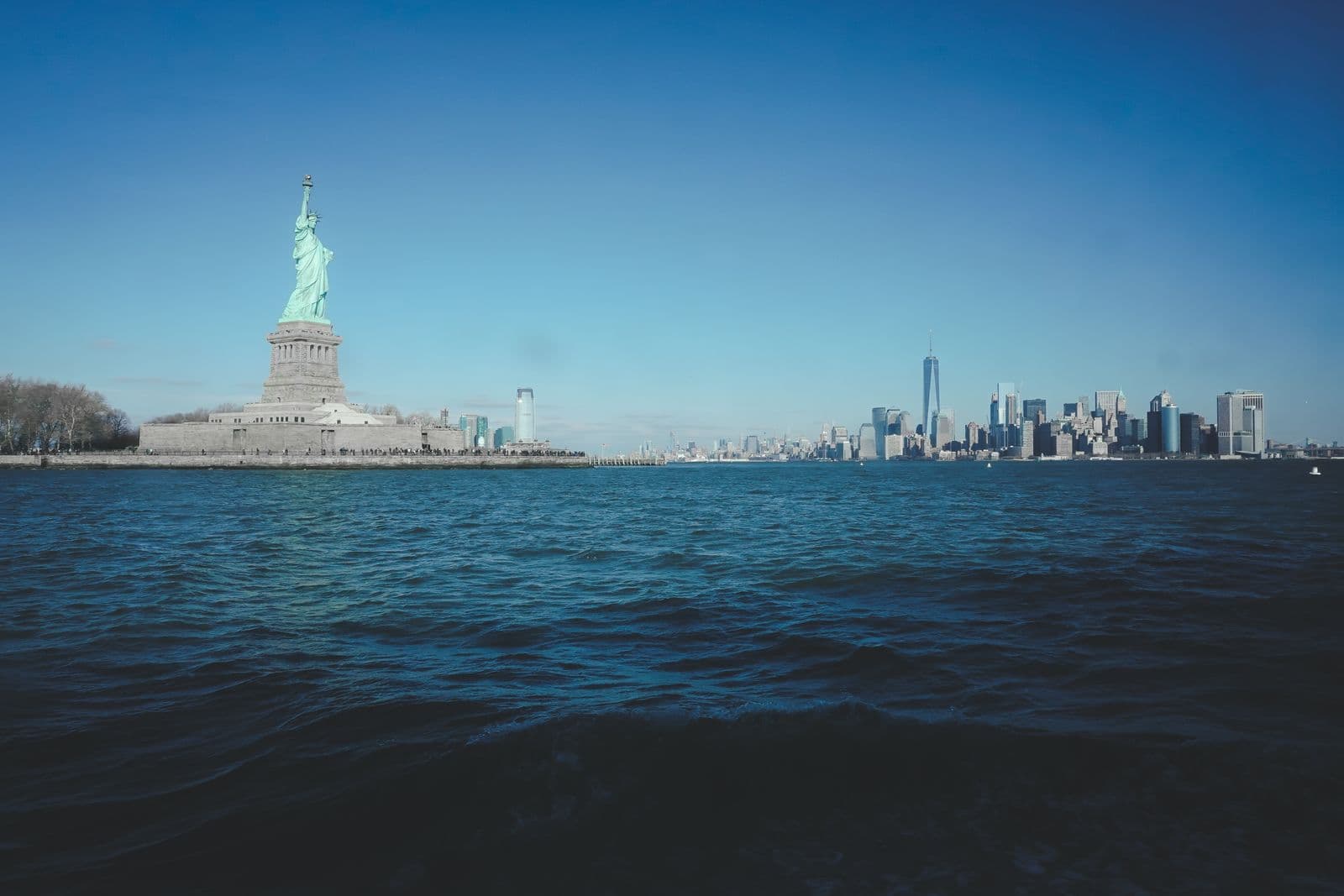 The Statue of Liberty with the Manhattan skyline across the water.